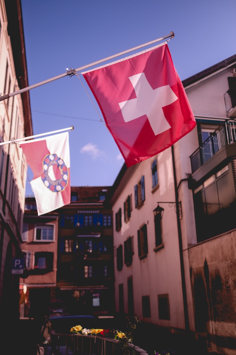 Swiss flags are waving in a european street.